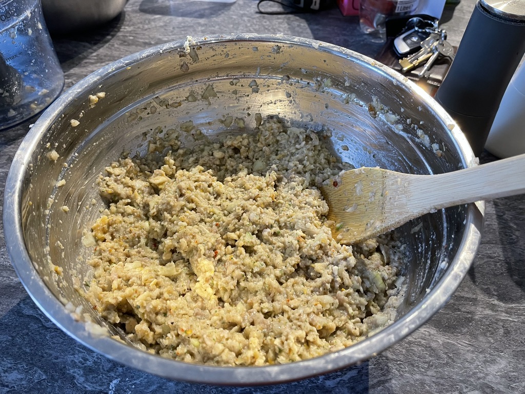 Stuffing mixture in a mixing bowl with pork sausage meat added